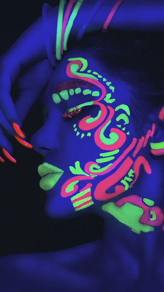 Woman with glowing neon face paint under UV light