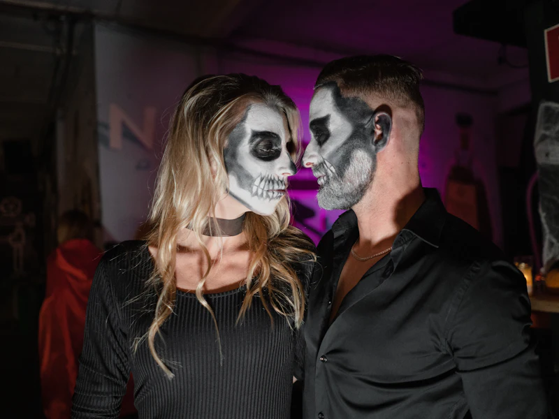 Couple in matching skeleton face paint for a Halloween party